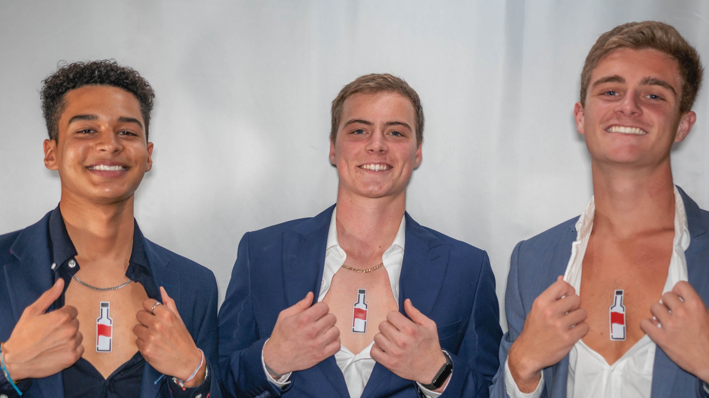 college guys in suits exposing their chests revealing a flagaholics logo