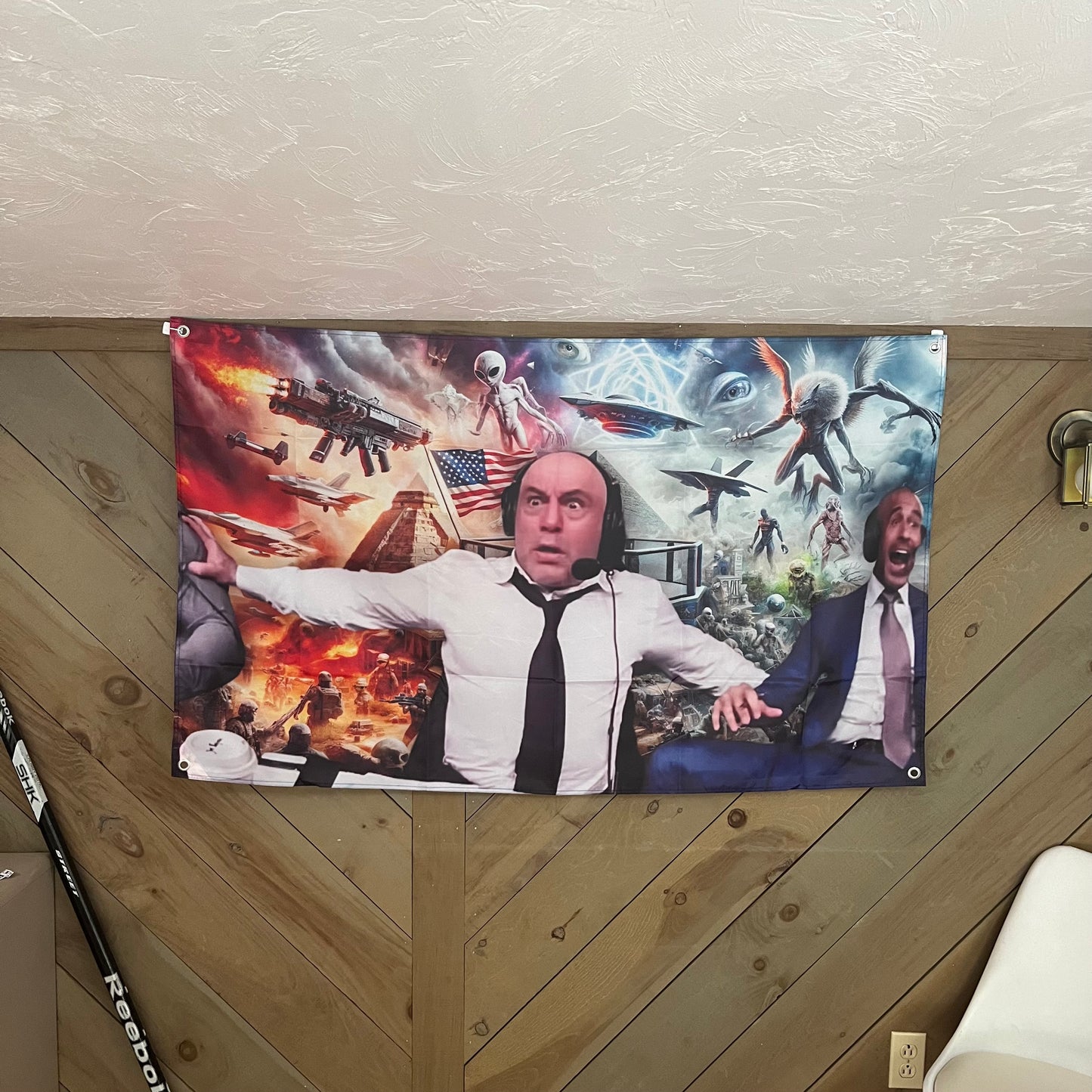 Joe Rogan flag displayed in a modern room, emphasizing the humorous and chaotic sci-fi battle scene with Joe Rogan and another man, ideal for adding a fun and bold touch to any space.