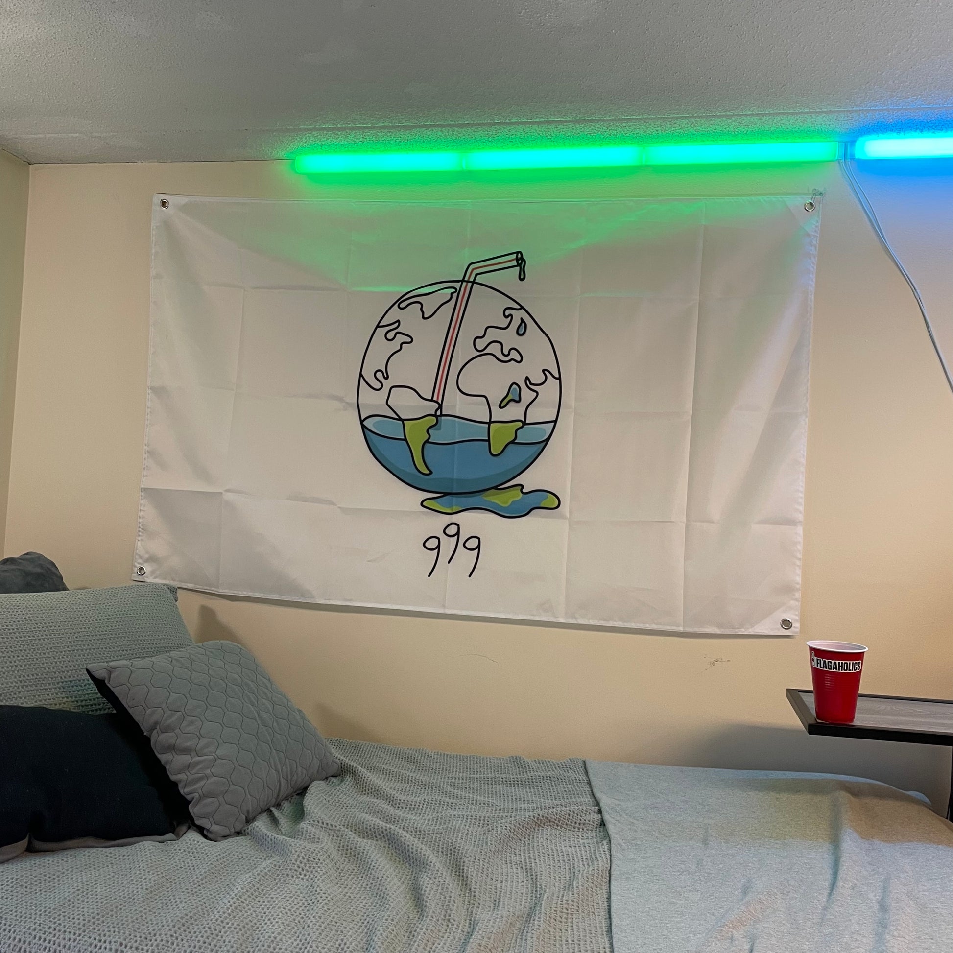 flag of a globe with a juice box straw in it with a "999" for juice wrld hung up in a college dorm room