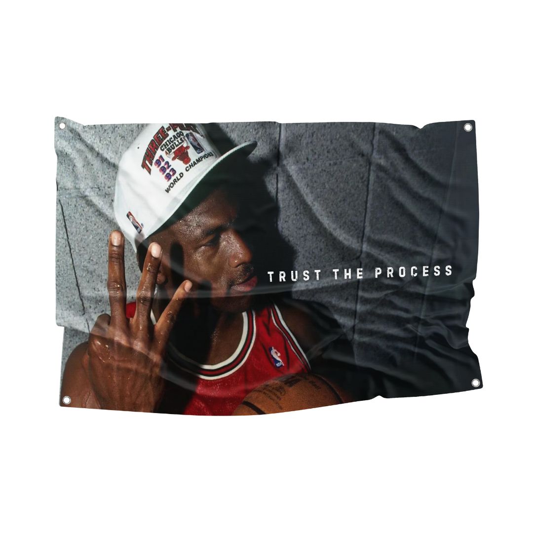 Michael Jordan flag featuring the iconic basketball player holding three fingers up, with the text "Trust the Process." Made from sturdy polyester blend with ultra HD printing and rust-free metal grommets.