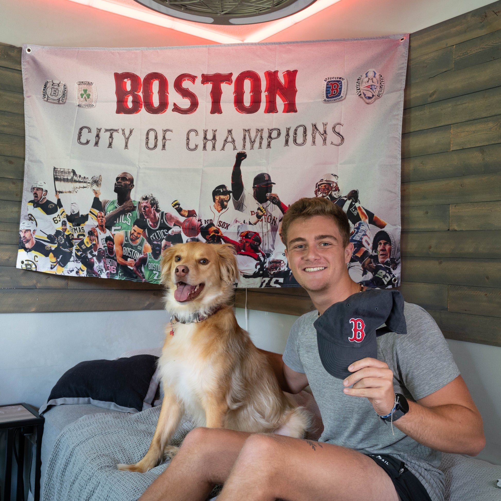 college guy and dog in front of boston sports flag