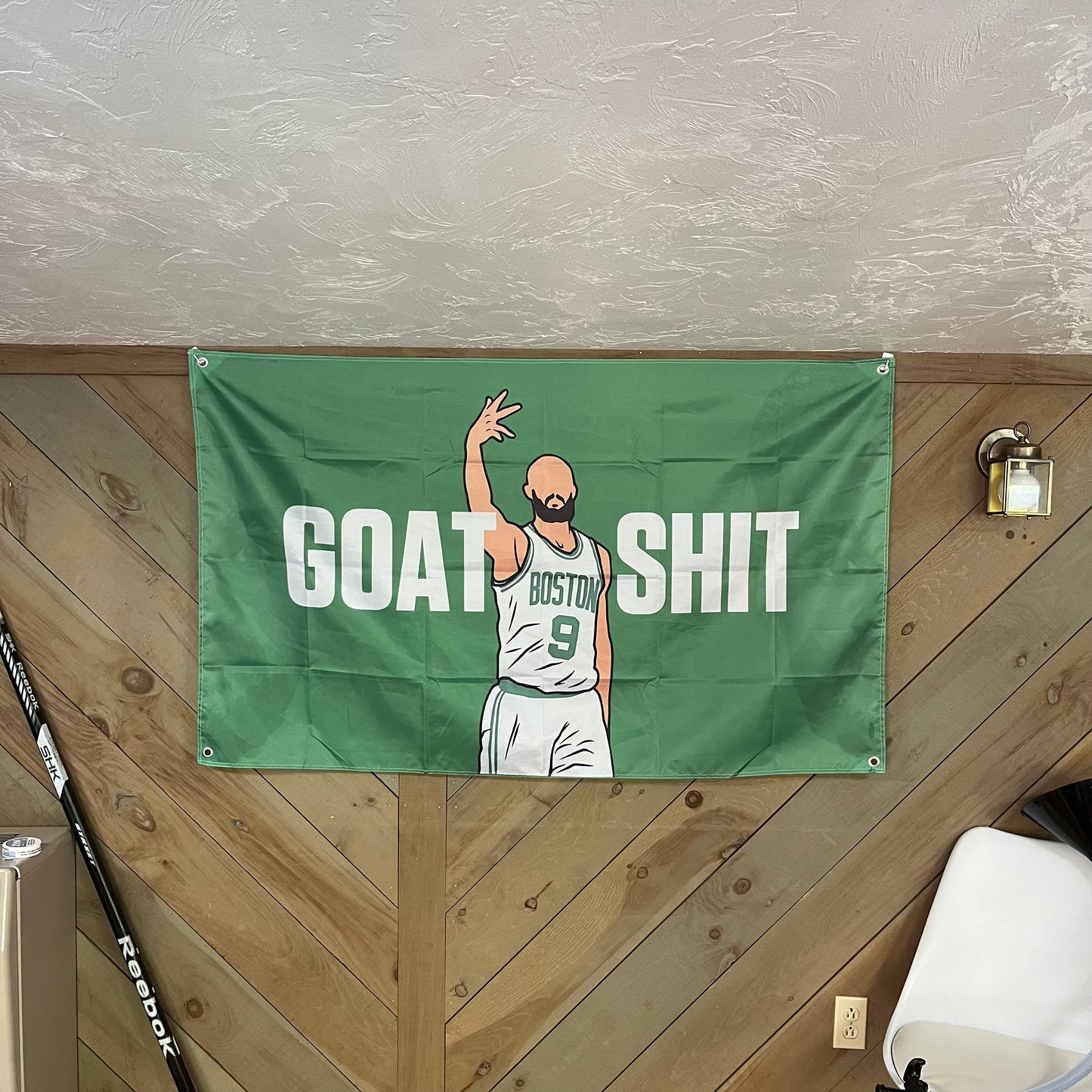 Stylish room decor with a 'GOAT SHIT' flag depicting Derrick White in a Boston Celtics jersey, ideal for sports enthusiasts and modern interiors