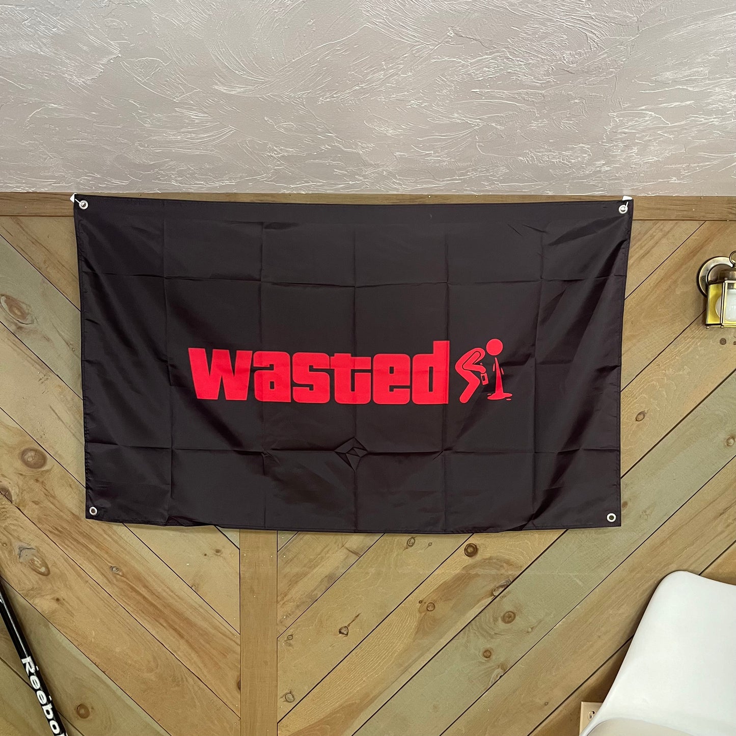 The "Wasted" flag displayed in a room setting, highlighting its bold design and playful vibe, ideal for party decorations or dorm room decor.