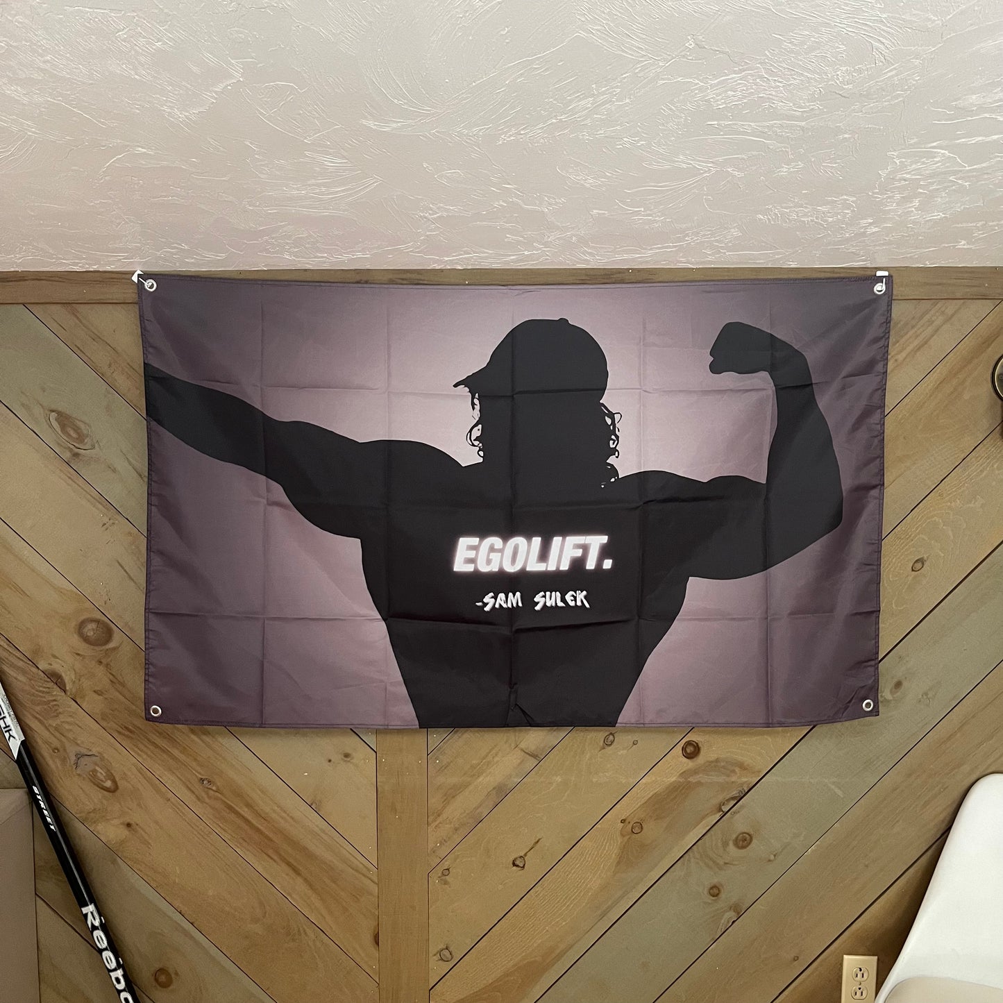A gym setting with the Sam Sulek flag displayed on the wall, illustrating its motivational impact and how it enhances the environment for fitness and bodybuilding enthusiasts.
